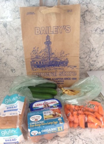 bread, butter, eggs, carrots, bananas and cucumbers all packaged in plastic