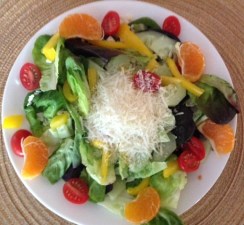 plate of fresh vegetables topped with shredded cheese