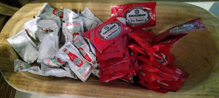 tray of small packages of ketchup and soy sauce