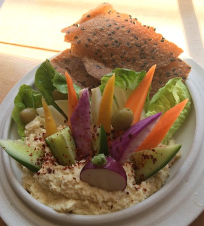 enticing salad base with veggie sticks, lettuce leaves and a small sandwich in the back