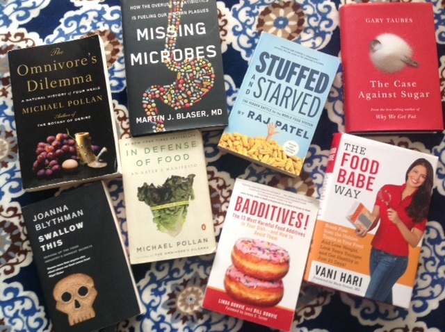 a display of books including Omnivore's Dilemma, Missing Microbes, Stuffed and Starved, The Case Against Sugar, Swallow This, In Defense of Food, Baddititves, and The Food Babe Way