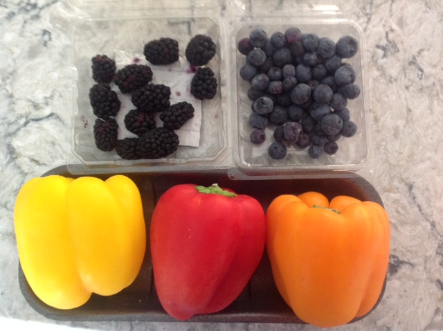 some remaining blackberries, blueberries with a yellow, red, and orange bell peppers