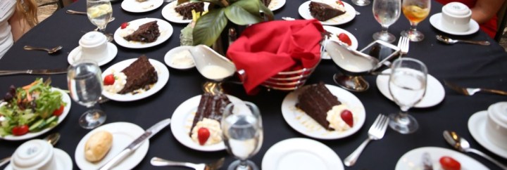 banquet setting with place settings, bread plate, a salad, and cake for dessert