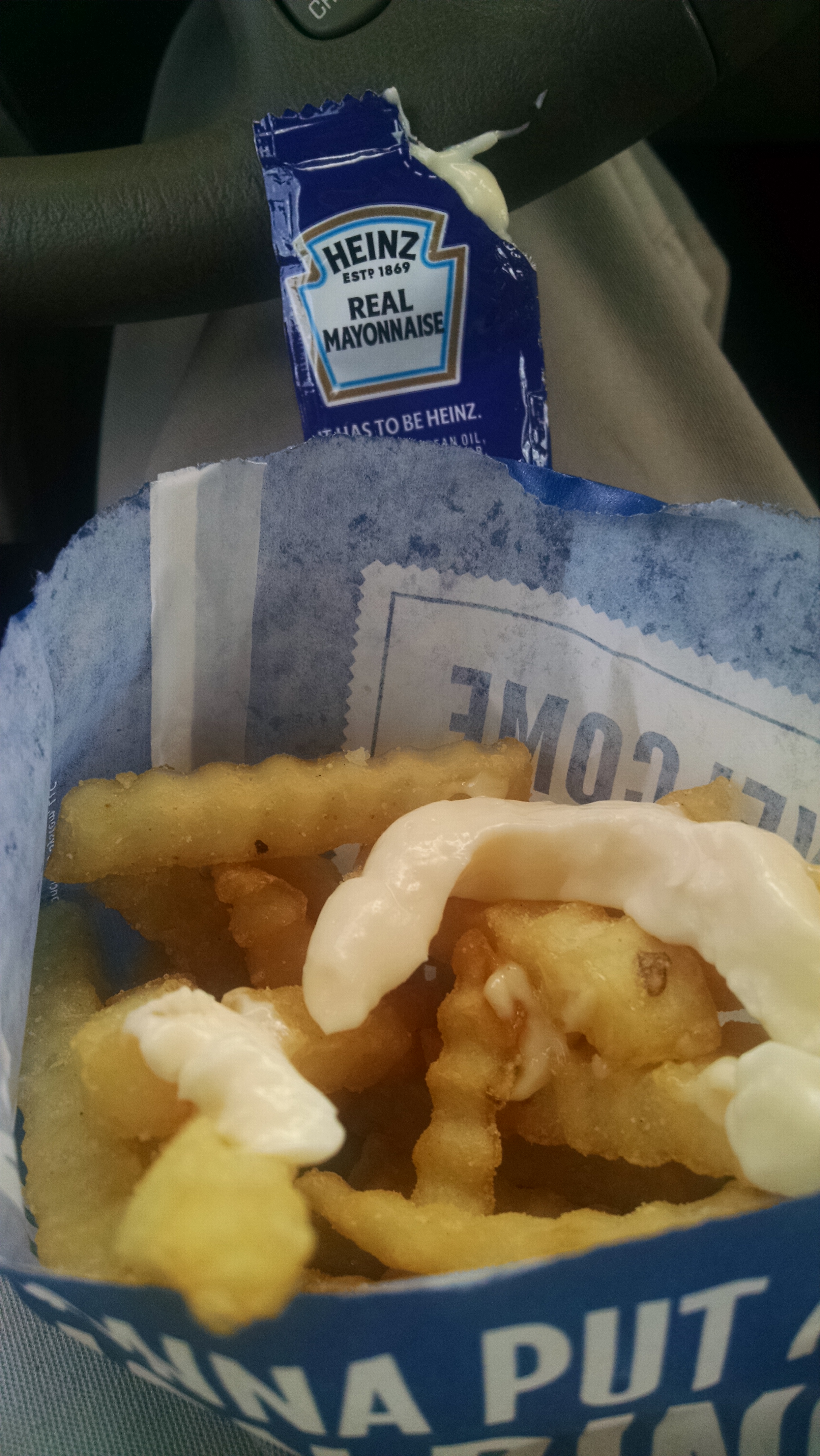 French fries from a fast-food restaurant with a stream of mayo.
