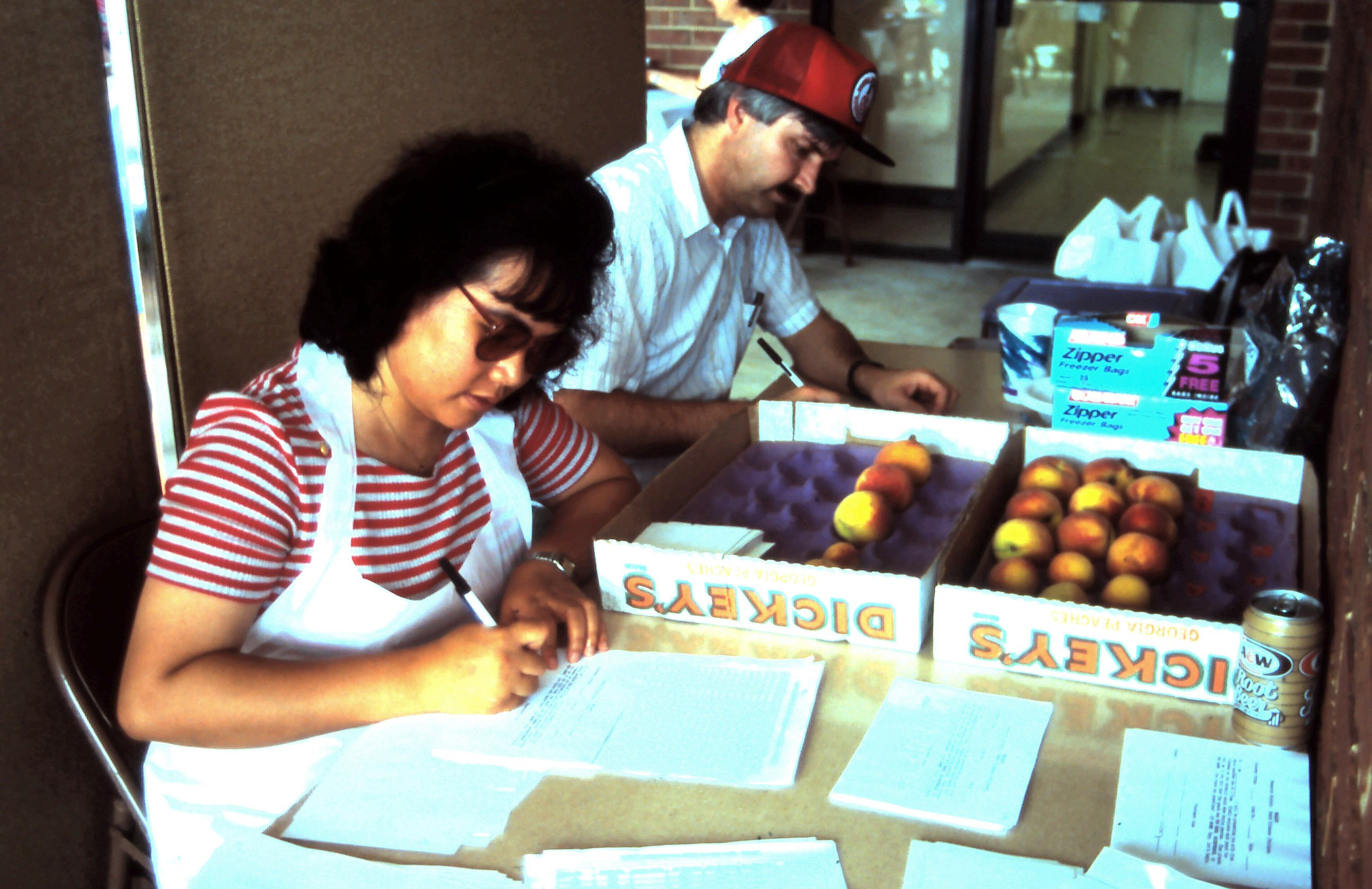 two people preparing score sheets for peach tests