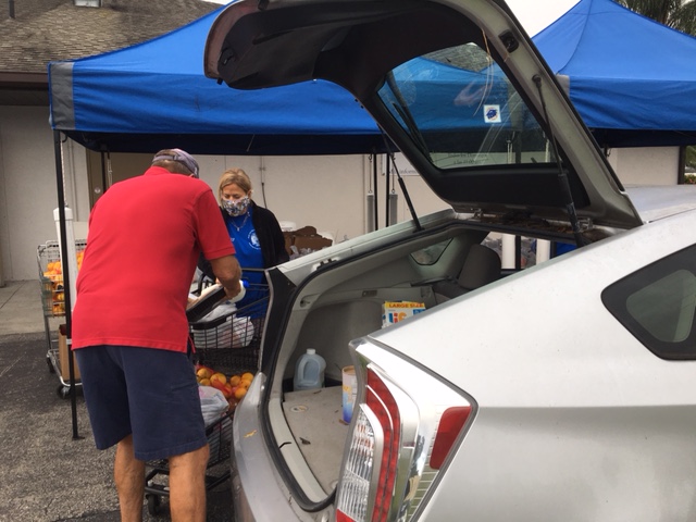 man putting food into the hatch of a client's car