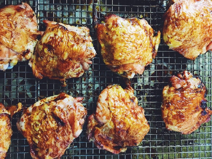 chicken thighs with skin roasting on the grill