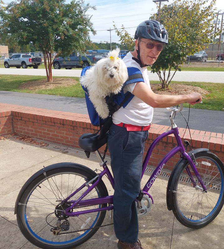 My dog in a backpack and me on my bike at a stop on the Swamp Rabbit Trail